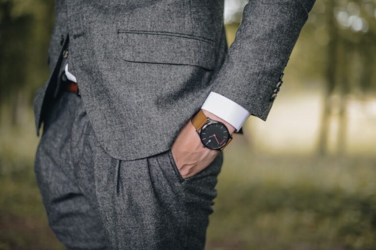 Close-up of a business litigation lawyer in a gray suit, standing confidently with one hand in their pocket, showcasing professionalism and attention to detail.
