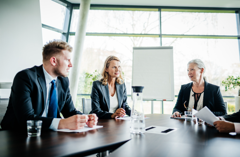 A business team in discussion, reviewing documents that may relate to the voting rights, financial contributions, or decisions made by a majority shareholder within the organization.