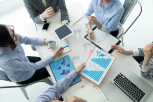 A group of professionals discussing documents, symbolizing the decision-making process of how to remove a member from an LLC, including analyzing agreements and potential legal steps.