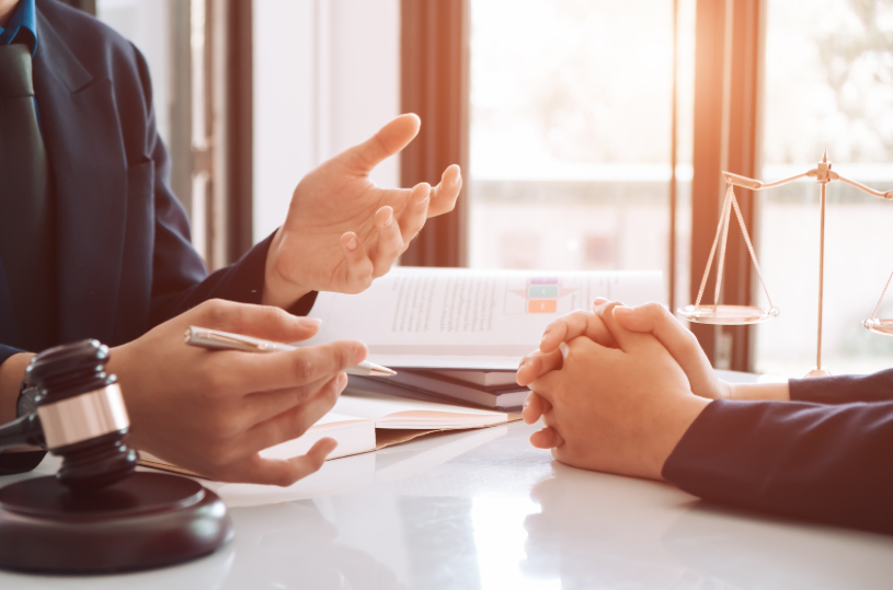 A lawyer consulting a client, with legal documents on the table, illustrating the process of how to remove a member from an LLC, involving legal advice on the procedures and requirements.