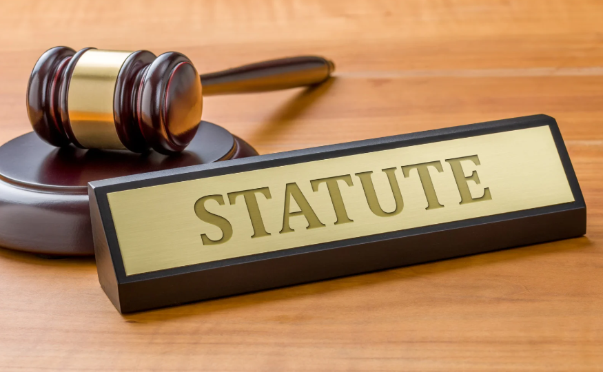 A gavel and plaque labeled "STATUTE," symbolizing the Texas Long Arm Statute, which allows Texas courts to exercise jurisdiction over out-of-state defendants in certain legal matters.