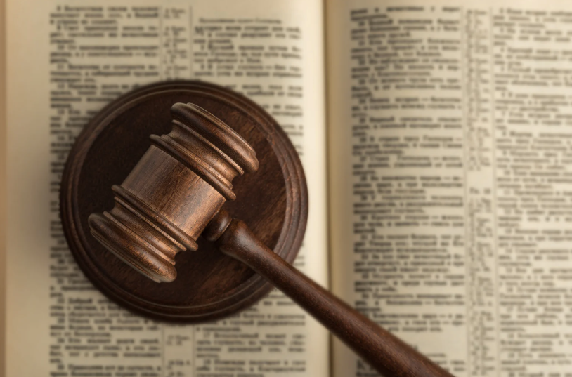 A gavel resting on a legal text, symbolizing the legal process surrounding the filing of a motion to set aside a default judgment. This motion is typically filed when a party wants to challenge the validity of a judgment due to reasons like not being properly notified or failing to appear.