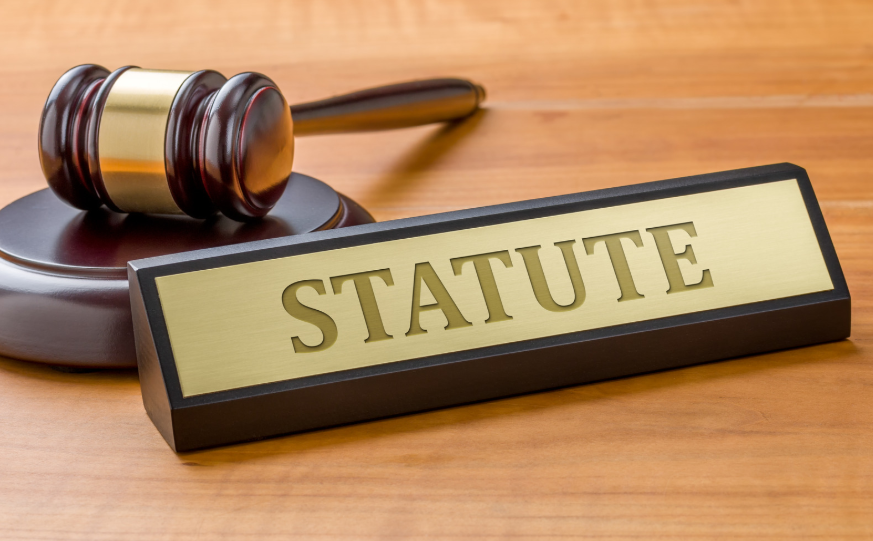 A gavel and a plaque marked "STATUTE," representing the importance of statutes in Texas breach of contract law, outlining the legal provisions for resolving disputes.