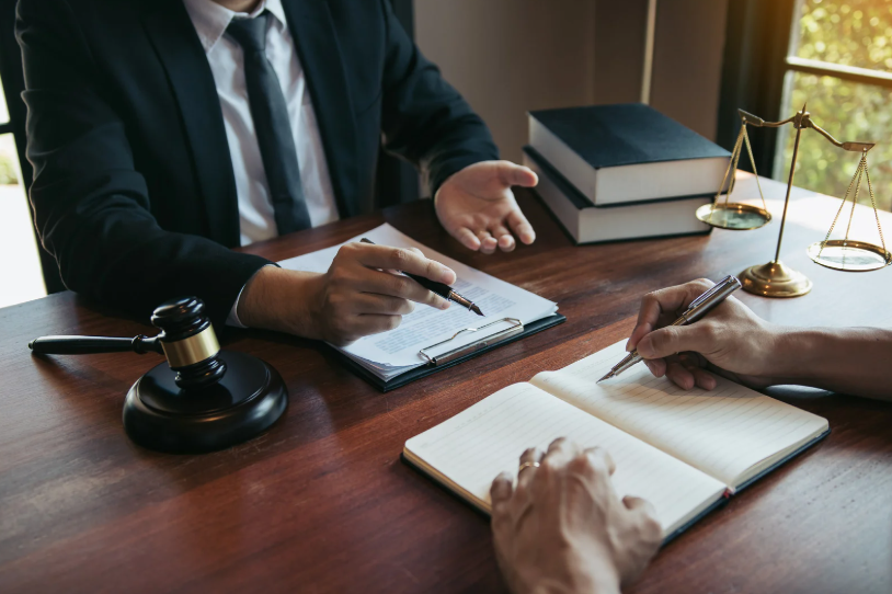 A lawyer and a client discussing legal matters at a table, focusing on Texas breach of contract law and how it applies to resolving contract disputes and damages in Texas.