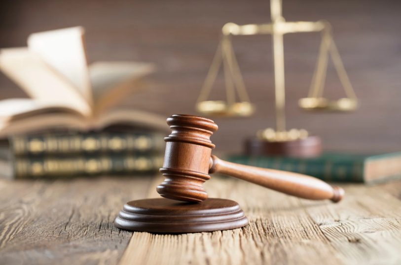 A close-up shot of a gavel, scales of justice, and law books, which symbolize the foundation of legal matters and the principles behind the Texas Deceptive Trade Practices Act. This act protects consumers against false, misleading, or deceptive business practices.