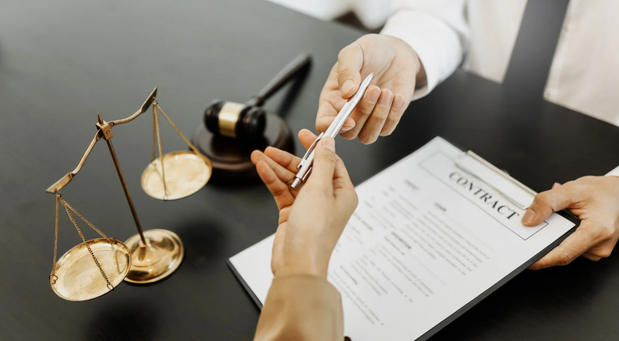 A person handing over a pen to another individual while preparing to sign a contract. This image highlights the signing of legal agreements, which could relate to Texas independent contractor laws, emphasizing the formal process of contract execution for contractors in Texas.