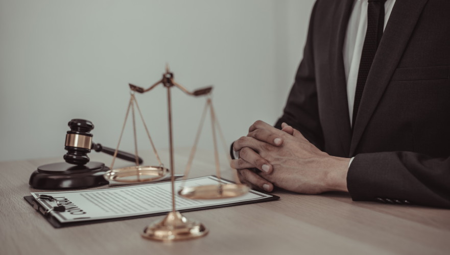 A lawyer seated at a desk with a contract and gavel, representing a case involving tortious interference in a legal dispute over wrongful interference in business or contractual dealings.