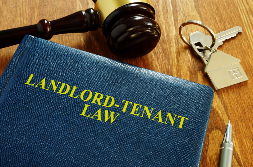 A book titled "LANDLORD-TENANT LAW" next to a gavel and keys, representing legal knowledge on what a landlord cannot do in Texas, like illegal eviction practices or withholding security deposits unfairly.