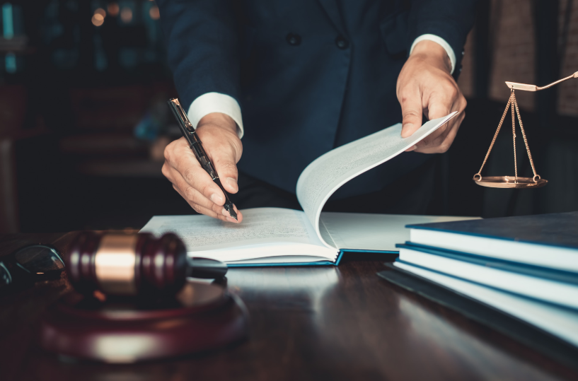 A business litigation lawyer signing a document in a legal office, highlighting the role of an attorney in handling complex business litigation cases.