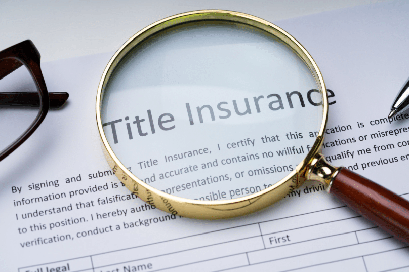 A magnifying glass over the title insurance document highlights the importance of carefully reviewing the terms of the policy. This reflects the need to understand what title insurance covers, such as protection from potential legal disputes or claims about the ownership of the property.