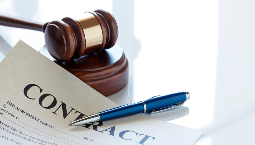 Contract document with a pen and gavel on a reflective desk, representing the expertise of a contract lawyer.